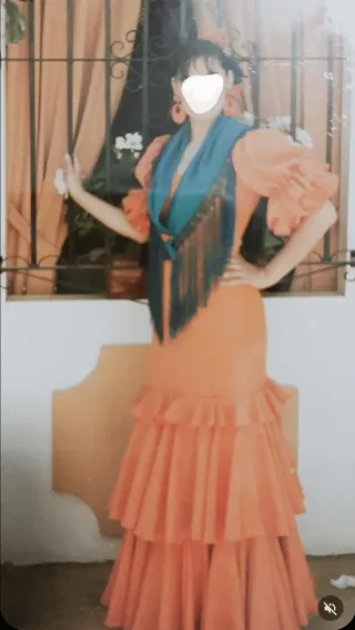 Traje de flamenca naranja con lunares blancos.
