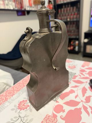 Botella antigua de metal la bisagra esta rota