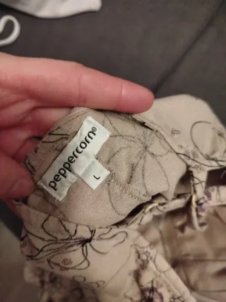 Camiseta tirantes floral beige y morado.