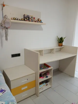 Habitación infantil con cama y cajones.