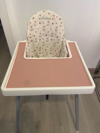 Trona IKEA con cojín y mantel rosa