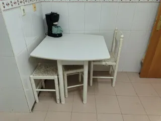 Mesa de cocina blanca con silla y taburetes