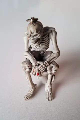 Llavero figura esqueleto fumando y cagando en WC
