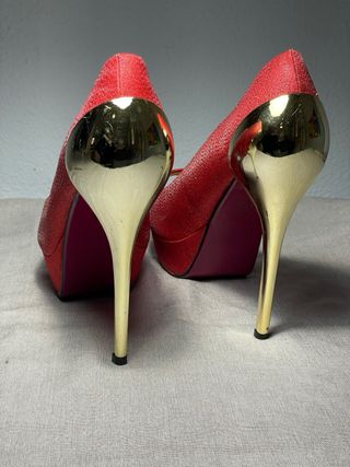 Zapatos de tacón rojos con detalles dorados