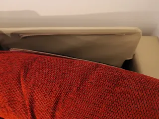 Sofá cama piel y tela antimanchas beige/rojo.