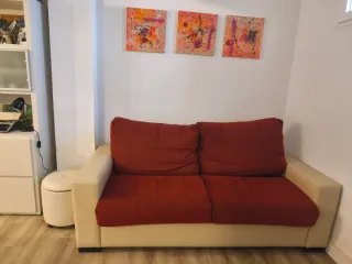 Sofá cama piel y tela antimanchas beige/rojo.