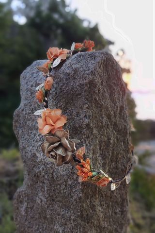 Corona de flores naranja y dorada