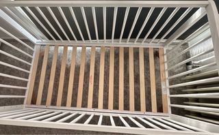 Cuna de bebé blanca con patas de madera