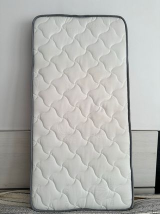 Cuna de bebé blanca con patas de madera