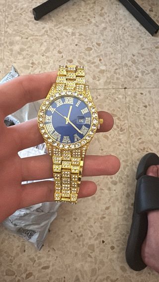 Reloj de lujo dorado con detalles brillantes