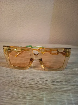 Conjunto Bolso impermeable y gafas doradas