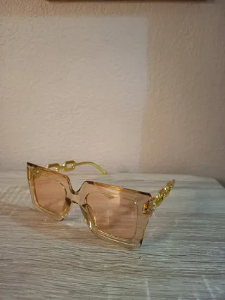 Conjunto Bolso impermeable y gafas doradas