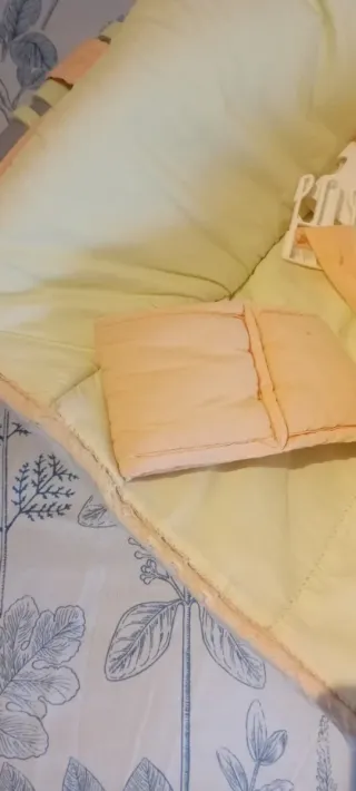 Hamaca para bebé amarilla con diseño de mariposa.