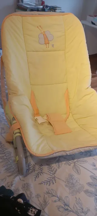Hamaca para bebé amarilla con diseño de mariposa.