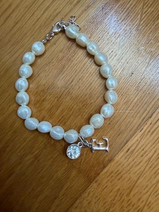 Pulsera perlas con charm letra E y brillante.