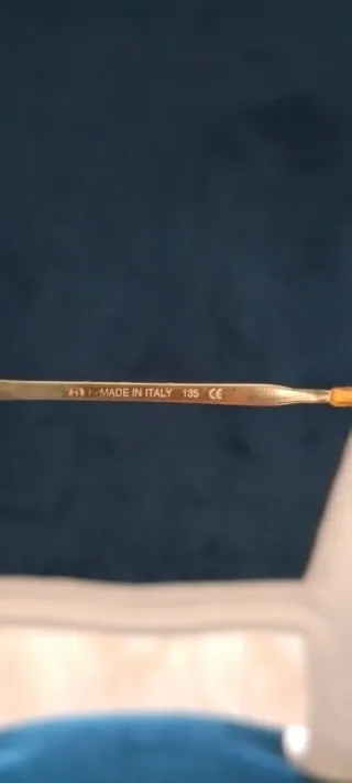 Montura de gafas doradas con detalles rojos