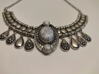 Collar plateado con piedras blancas grisáceas.