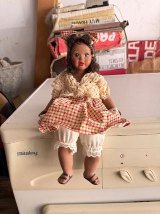 Muñeca sentada con vestido de cuadros