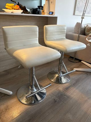 Taburetes altos blancos y plateados