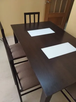 Mesa de comedor oscura con sillas
