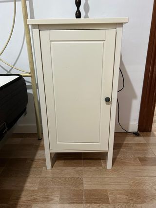 Mesita de noche beige con puerta y lamparita