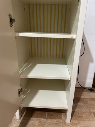 Mesita de noche beige con puerta y lamparita