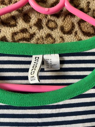 Camiseta de rayas blancas y negras con borde verde