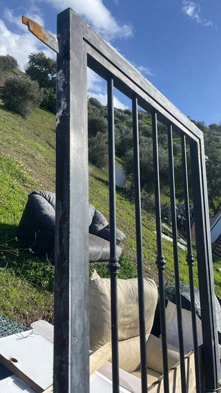 Puerta metálica exterior con barrotes mazizo