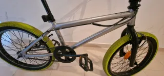 Bicicleta BMX plateada con ruedas verdes