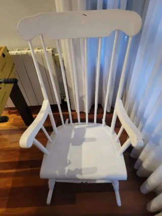 Due dondoli in legno bianco con cuscino. Cuscino a quadri in blu, giallo e bianco.