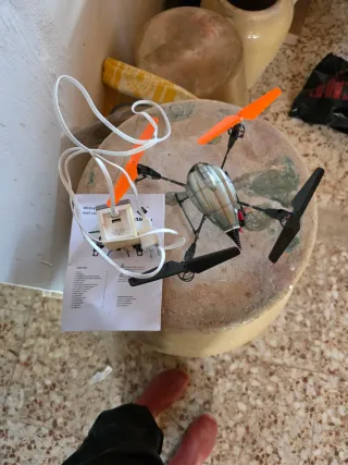 Dron de juguete plateado con hélices naranjas