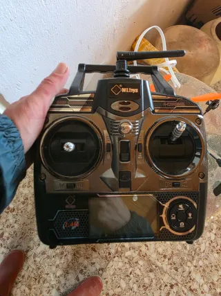 Dron de juguete plateado con hélices naranjas