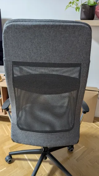 Silla de oficina gris con reposacabezas.