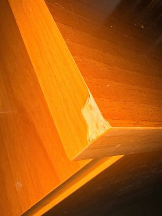 Cómoda de madera marrón, tiene una esquina mal