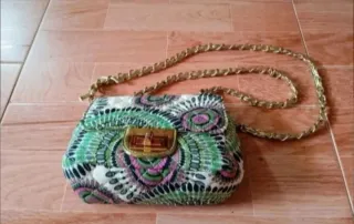 Bolso tela semi-acolchada múltiples tonos verdes.