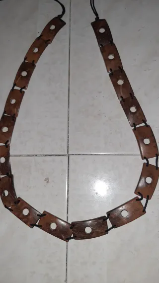 Cinturón de madera con cordón negro.