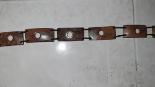 Cinturón de madera con cordón negro.