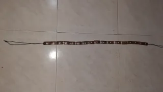 Cinturón de madera con cordón negro.