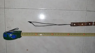 Cinturón de madera con cordón negro.