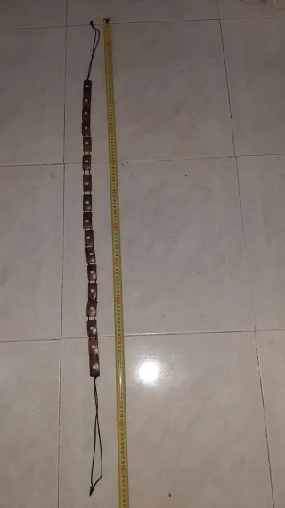 Cinturón de madera con cordón negro.