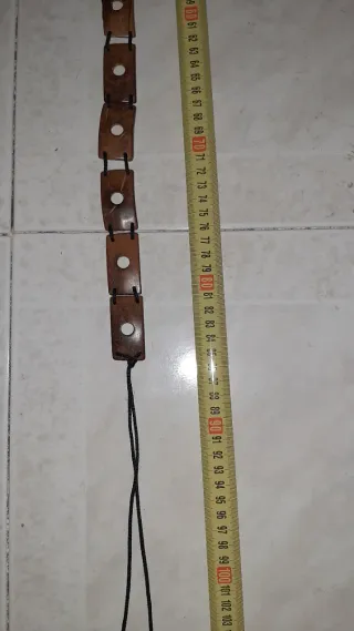 Cinturón de madera con cordón negro.