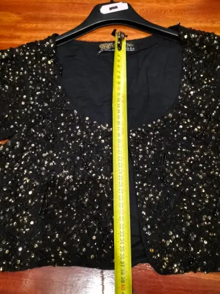 Chaquetilla fiesta lentejuelas negra y dorada.