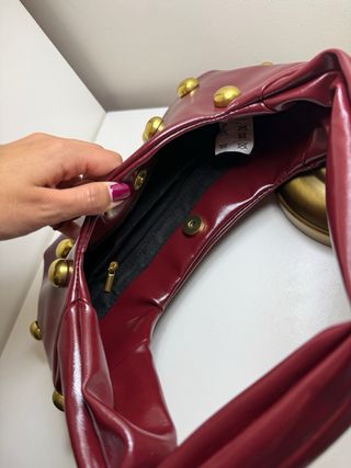 Bolsa de mão bordeaux com tachas douradas