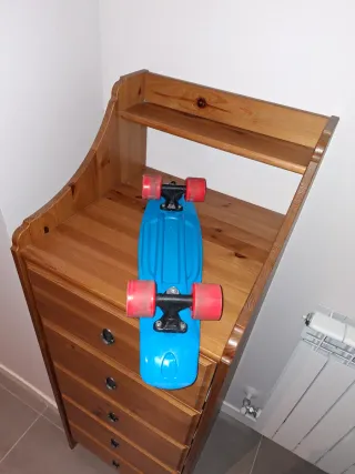 Monopatín azul con ruedas naranjas