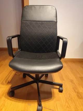 Mesa de escritorio con lampara y silla.