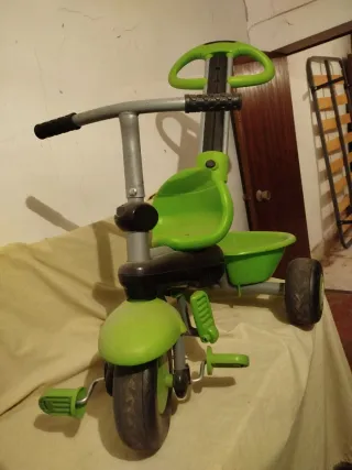 Triciclo infantil verde con capota.