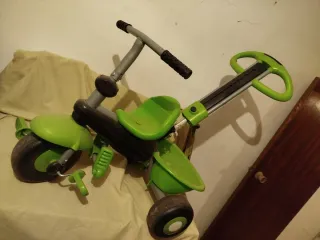Triciclo infantil verde con capota.