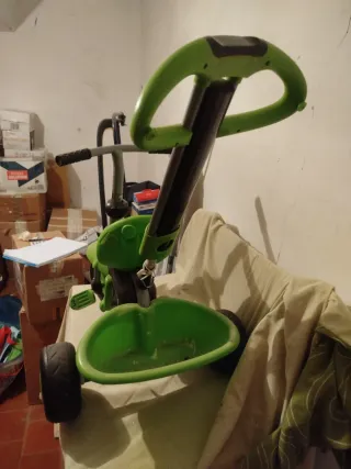 Triciclo infantil verde con capota.