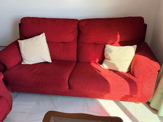 Sofá de tela rojo y cojines beige