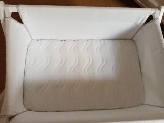 Minicuna con ruedas y colchón antiplagiocefalia.